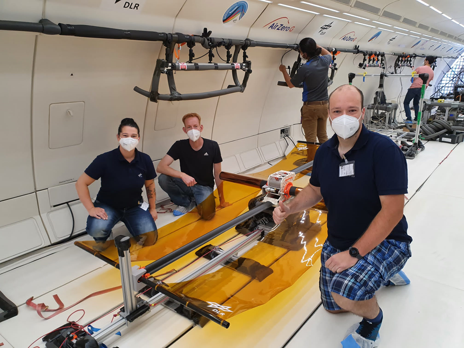 Team des Parabelflugs vor dem Experiment mit den (noch) unter Schwerkraft durchhängenden Photovoltaikfolien