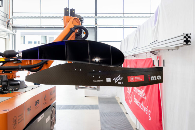 Mobiler Roboter mit Montagevorrichtung und eingespannter Landeklappe in Montageposition, Detailaufnahme (Bildnachweis: Markus Hörster, TU Braunschweig)